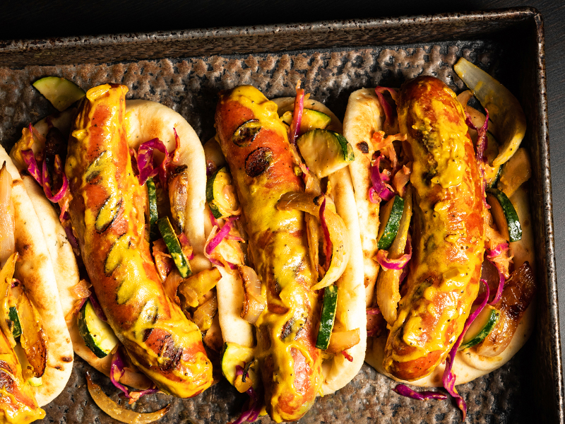 Overhead photo of four prepped and loaded bratwursts