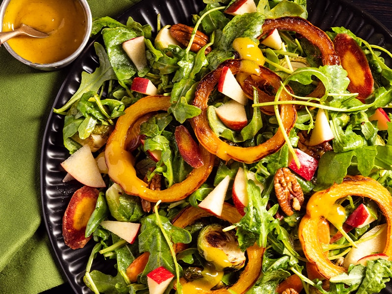 overhead photo of salad in bowl, topped with rings of butternut squash