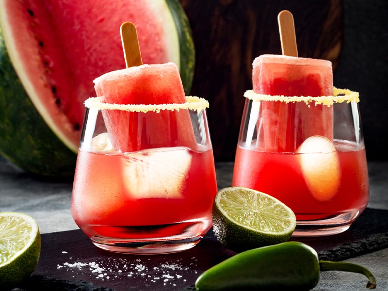 two glasses with watermelon-pink popsicles and drink inside